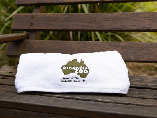 White towel with Australia Zoo logo on a wooden bench
