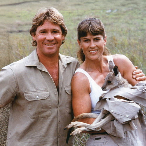 Steve and Terri Irwin and woman standing together with a kangaroo, outdoors.